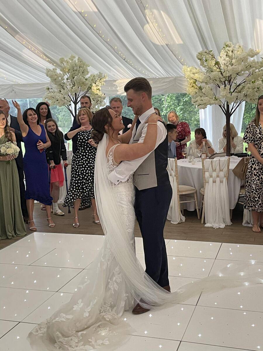 Bride and groom raised in the air by happy guests on the dance floor