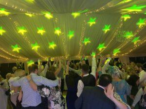 Guests singing and dancing with a 2010s pop wedding DJ in Herts