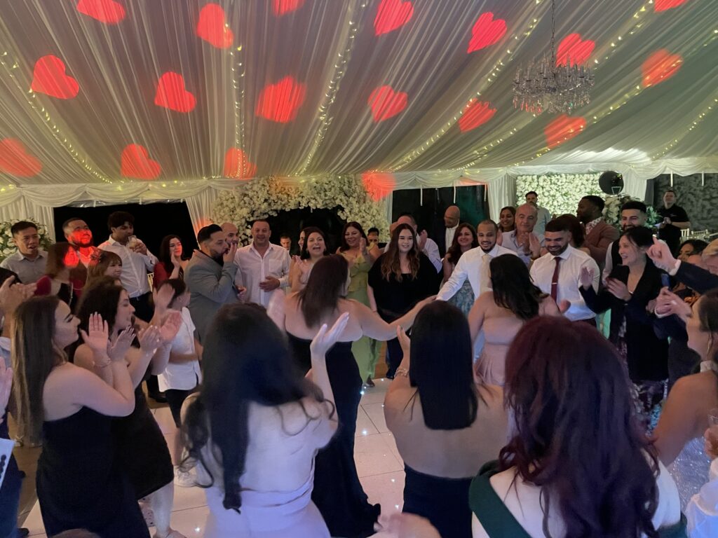 Guests having fun under dynamic wedding party lights