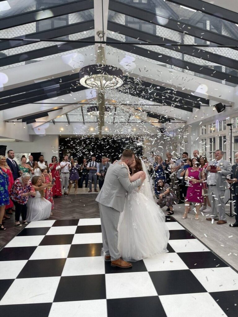 Romantic first dance kiss under soft lighting