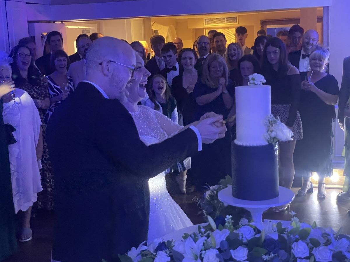 Newlyweds cutting the cake during Sheene Mill wedding
