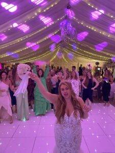 Bride throwing her bouquet during wedding reception at Mulberry House in Essex