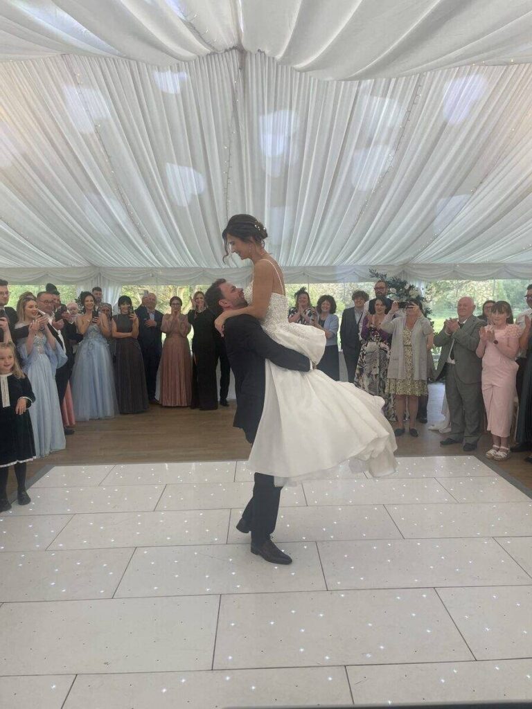 groom lifts the bride in the air during the first dance song