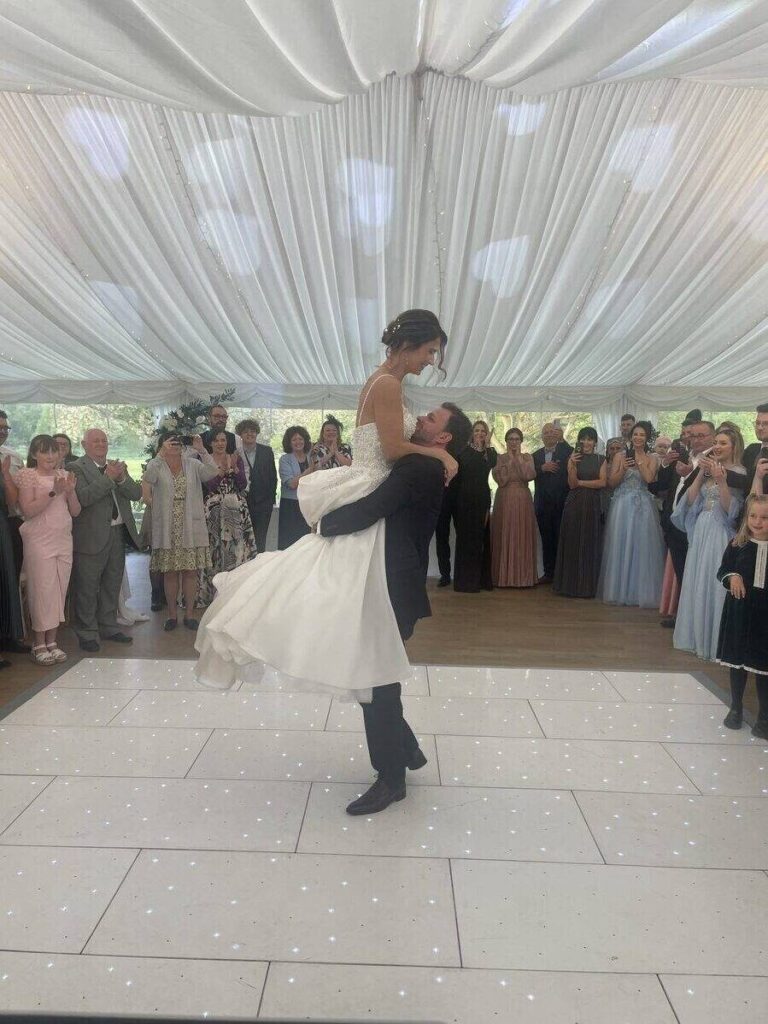 groom lifts the bride in the air during the first dance song