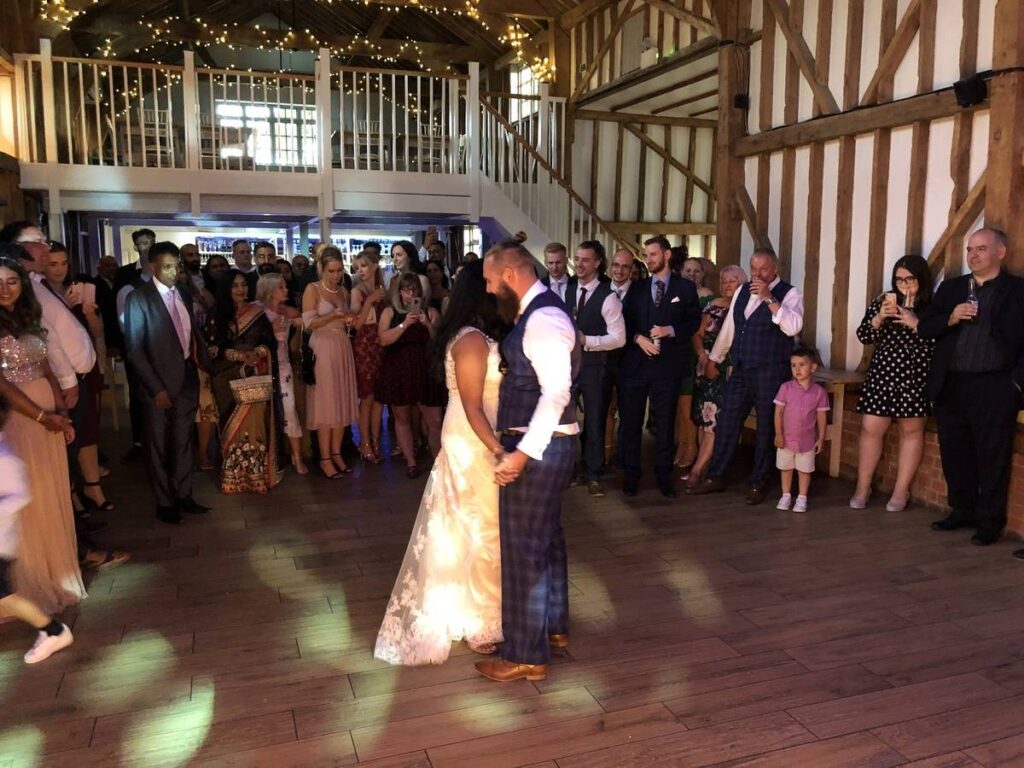 Bride and groom holding hands during first dance